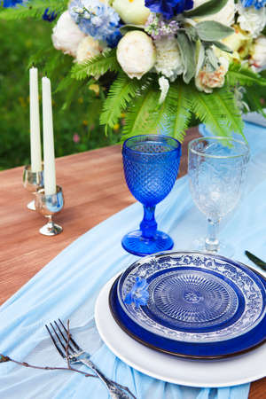 Bouquet of pink, violet and yellow flowers on a table set for dinner, close up の写真素材