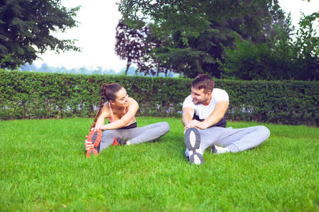Young happpy couple exercising and stretching muscles before sport activity の写真素材