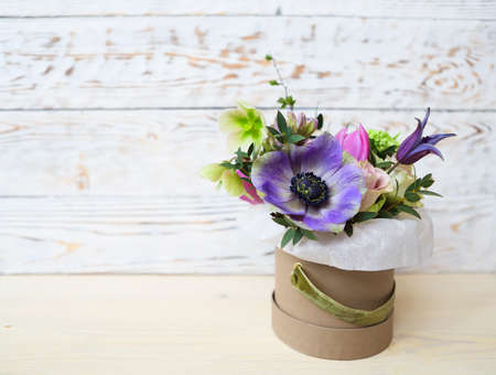 Bouquets of pink and violet flowers in the box on a woden background, close up の写真素材