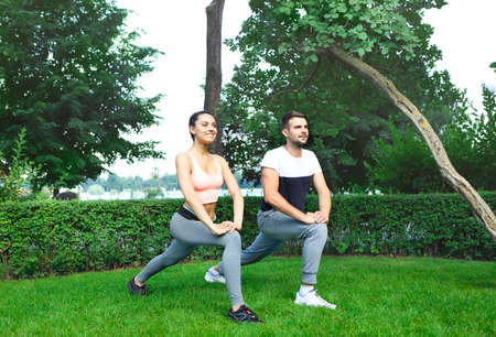 Young happpy couple exercising and stretching muscles before sport activity の写真素材