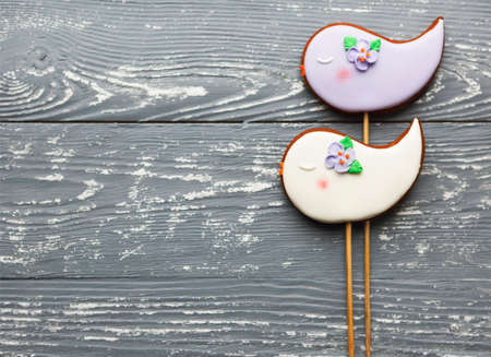 Violet and white romantic cookies on a gray wooden background with copy space