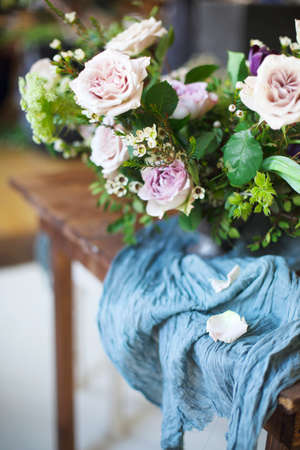 Bouquet of pink flowers on a table set for dinner with candles, close-upの写真素材