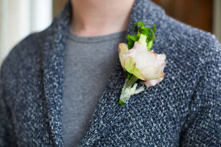 Gentle groom boutonniere with roses and beads. Close up