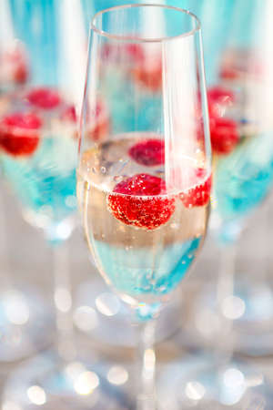 Champagne glasses with raspberry. Summer pool partyの写真素材