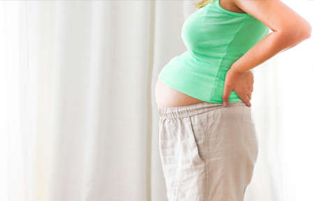 Pregnancy, motherhood- close up of happy pregnant woman indoorsの写真素材