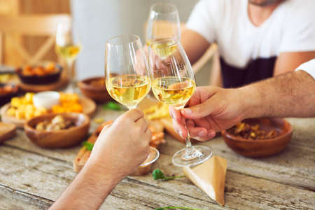 Hands with white wine glasses. Dinner and celebrationの写真素材