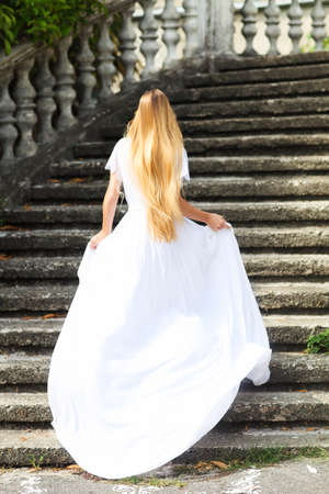 Beautiful happy running bride outdoors in parkの写真素材