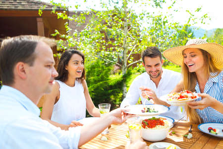 Dinner variety of Italian dishes and lemonade on wooden table in the gardenの写真素材