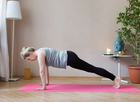 Middle aged or mature woman doing yoga indoorsの写真素材