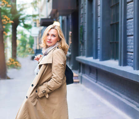 Middle age women goes through the city and smiles. Happiness concept.の写真素材