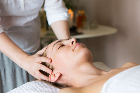Young pretty woman face massage or beauty treatment in spa salonの写真素材