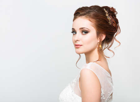 Young pretty caucasian bride in wedding dress at studioの写真素材