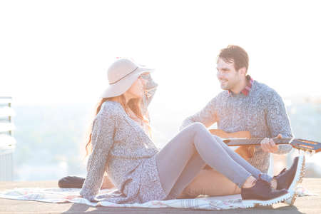 Young man and woman with guitar  having fun outdoors Love and relations conceptの写真素材