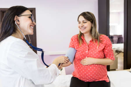 Young pregnant woman check up at doctors officeの写真素材