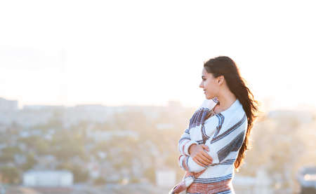 Young woman outdoors on city background in sunny dayの写真素材
