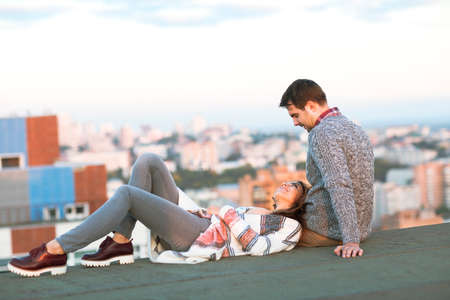 Young man and woman embrace and having fun outdoors on the roof Love and relations conceptの写真素材