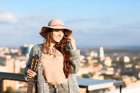 Young woman outdoors on city background in sunny autumn dayの写真素材
