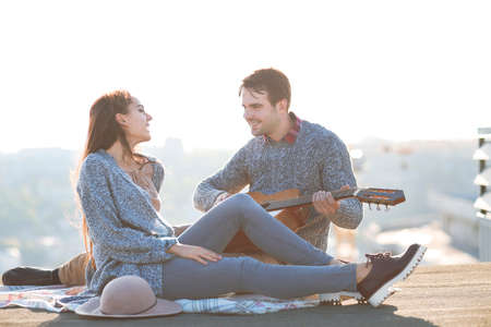 Young man and woman with guitar  having fun outdoors Love and relations conceptの写真素材
