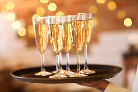 Champagne glasses on tray in bright lights. Party or celebration