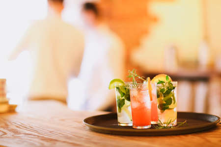 Two cocktail glasses on tray on wooden bar counterの写真素材