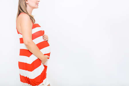 Young pretty smiling pregnant woman on white background in studio