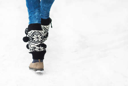 Woman walking in winter park. Shoes close up