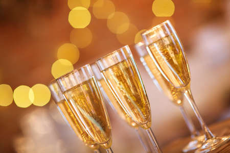 Champagne glasses on golden background. Party and celebration conceptの写真素材