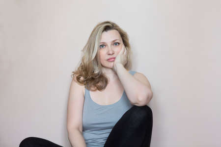 Portrait of smiling blonde middle age woman in the roomの写真素材