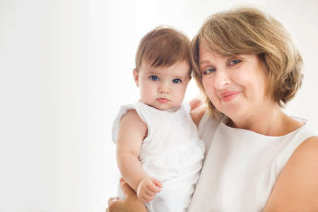 Mature woman embrace with baby girl. Grandmother and girl