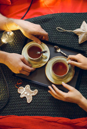 Christmas decoration and two tea cup at people hands. Top viewの写真素材