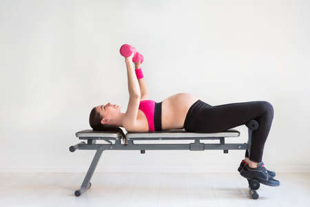 One young pregnant woman doing fitness exercises at studioの写真素材