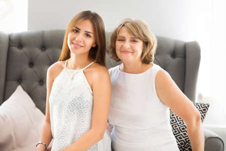 Mature woman embrace with young teen girl. Grandmother and girl