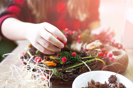 Christmas handmade wreath in young womans hands. Winter holidays celebration conceptの写真素材