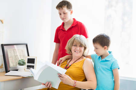 Mid-age woman with two young boys indoors. Family concept