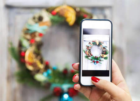 Woman makin photo of handmade Cristmas wreathの写真素材