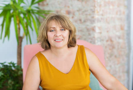 Mature woman sitting on chair in the living room