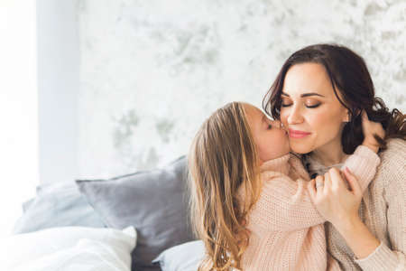 Young woman in the morning embrace with small girl. Love and family conceptの写真素材