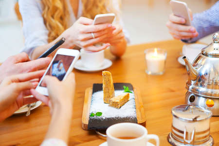 Friends take a food picture of dessertの写真素材