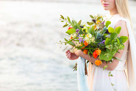 Beautiful happy bride wuth bouquet outdoors in the morningの写真素材
