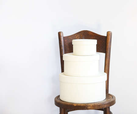 Three white boxes on a chair with copy spaceの写真素材