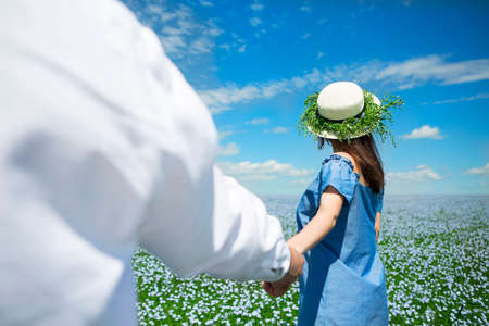 Young happy beautiful pregnant couple in linen fieldの写真素材