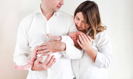 Portrait of the young happy parents with cute newborn baby daughterの写真素材