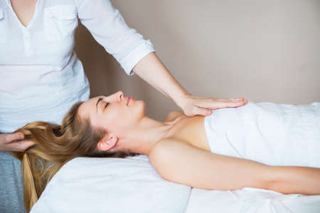 Beautiful young woman relaxing with hand massage at beauty spa. Close up の写真素材