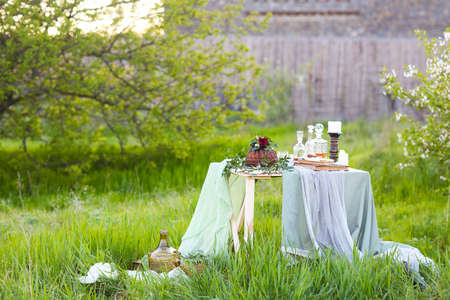 Table with chocolate cake decorated with flowers against a light green background with copy space
