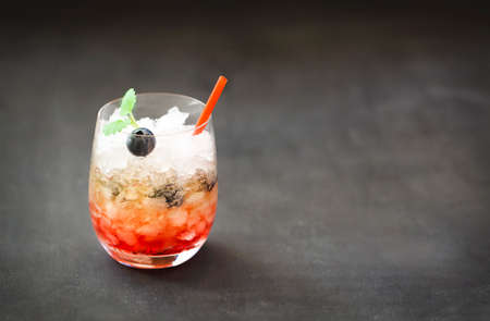 Blueberry cocktail with ice decorated by mint on a tableの写真素材