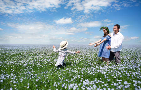 Portrait of a young pregnant family in linen field. Summer timeの写真素材