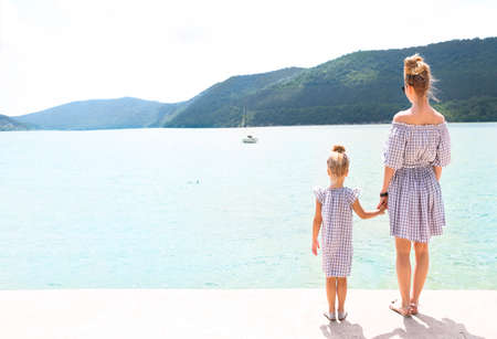 Young family by the lake. Daughter and mother together. Travel and holiday concept