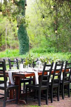 Decoration of wedding table with crystal vases, flowers and branches in botanical style in the...