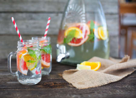 Two glasses of natural homemade lemonade by the jar on the table at summer party の写真素材