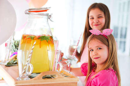 Kids by the candy bar with cake and citrus lemonade. Birthday partyの写真素材